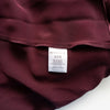 Close-up of a maroon garment with a 'Retrofete' label on a white background