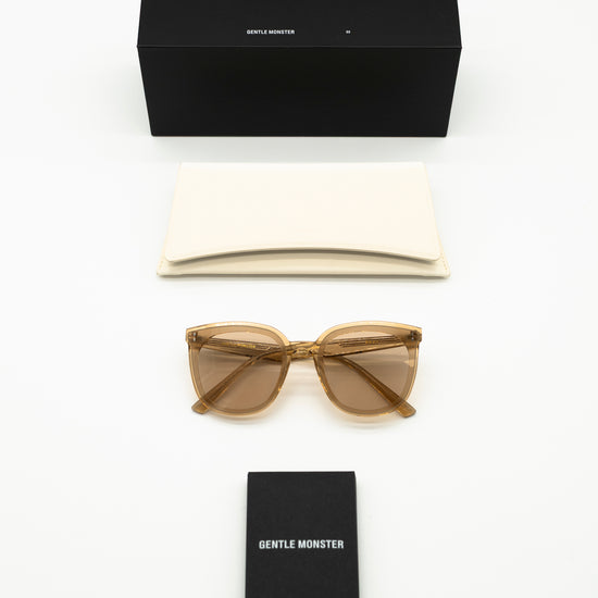 Sunglasses and black box with 'Gentle Monster' branding on a white background