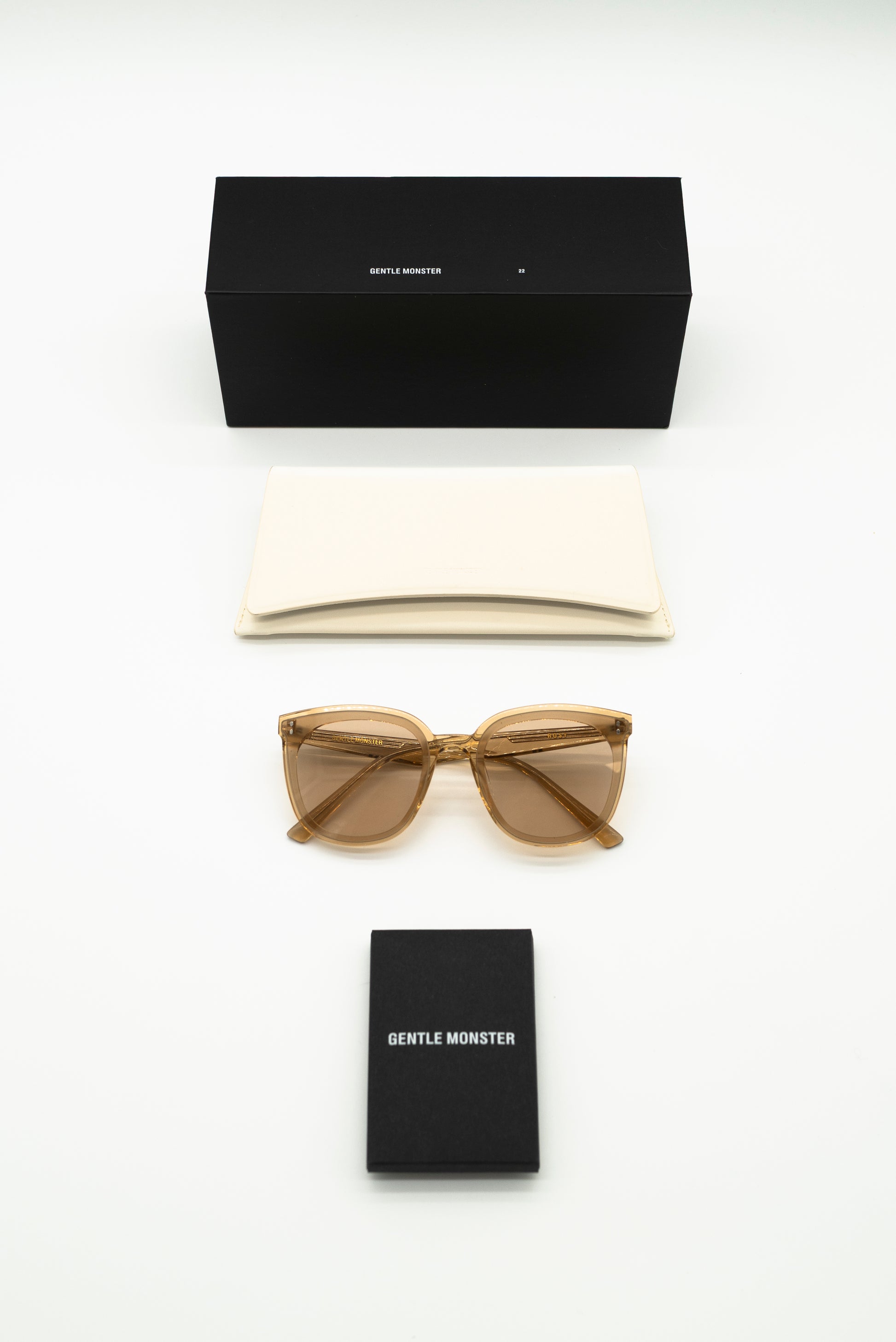 Sunglasses and black box with 'Gentle Monster' branding on a white background
