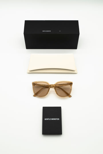 Sunglasses and black box with 'Gentle Monster' branding on a white background